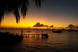 a sunset over a body of water with boats at Studio Le Balisier in Caritan