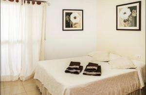 サンタクルス・デ・テネリフェにあるApartamento Atlantidaの白いベッドルーム(ベッド1台、タオル2枚付)