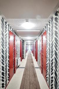 un couloir avec des casiers rouges et blancs et un long couloir dans l'établissement Hotel Donibane Saint-Jean-de-Luz, à Saint-Jean-de-Luz