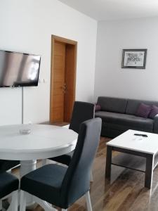 a living room with a white table and a couch at Apartman Petar in Nova Varoš