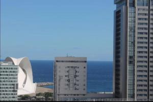 widok na dwa wysokie budynki i ocean w obiekcie Apartamento Atlantida w mieście Santa Cruz de Tenerife