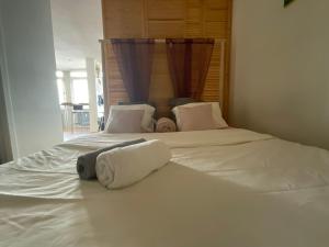- un grand lit blanc avec 2 serviettes dans l'établissement St Catherine - Sweet home - Bxl - Studio Apartment with city view, à Bruxelles