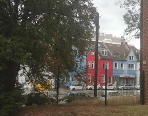 a group of colorful houses in a city at Adam's Hostel - Self Check-In & Only Private Rooms in Düsseldorf