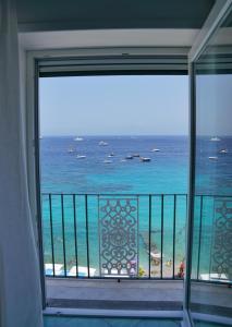 a room with a view of the ocean from a balcony at Casa Adelaide in Capri