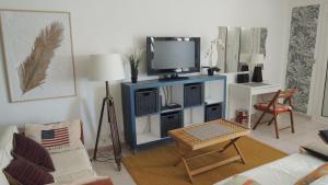 a living room with a tv on a blue cabinet at ACCI Cannes Marina in Cannes