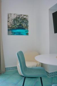 une chaise bleue et une table dans une pièce dans l'établissement Casa Adelaide, à Capri
