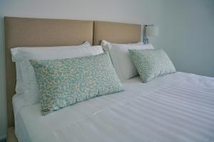 a white bed with two pillows on top of it at Casa Adelaide in Capri