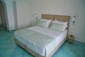 a bedroom with a large bed with white sheets and pillows at Casa Adelaide in Capri