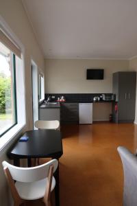 a kitchen with a table and chairs in a room at Cosy Nights - modern, self-contained with parking in Kerikeri