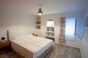 1 dormitorio con cama blanca y ventana en Mor Salkım Evi en Datca