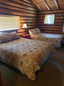a bedroom with two beds in a log cabin at Yellowstone Hot Springs Resort in Gardiner