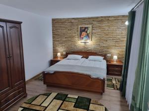 1 dormitorio con cama y pared de ladrillo en Casa Lucia en Anina