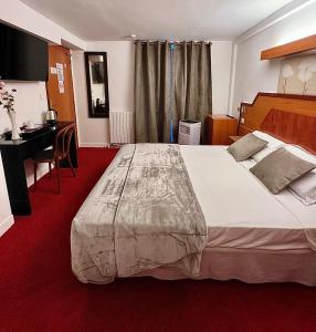 um quarto de hotel com uma cama grande e uma secretária em Le Nouvel Hôtel du Théâtre em Paris