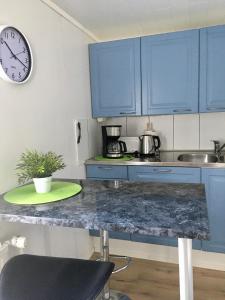 a kitchen with blue cabinets and a clock on the wall at Aurora Center 3 in Rovaniemi
