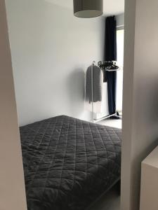 ブワディスワボボにあるApartament Harcerska-parking w garażu podziemnym w cenieのベッドルーム1室(黒い掛け布団付きのベッド1台付)