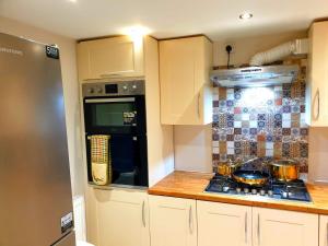 a kitchen with white cabinets and a stove top oven at Elegant 2 bed apartment in Manchester in Manchester