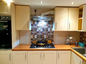 a kitchen with white cabinets and a stove top oven at Elegant 2 bed apartment in Manchester in Manchester