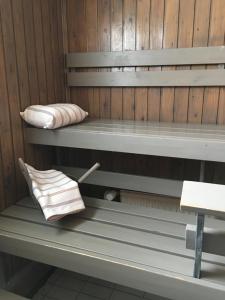 a bench in a sauna with a pillow and a towel at Aurora Center 3 in Rovaniemi