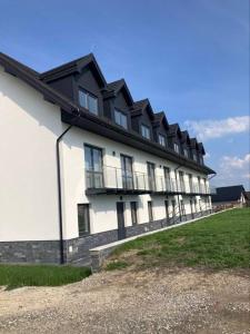 ein großes weißes Gebäude mit Balkon auf der Seite in der Unterkunft Tatranec in Lendak