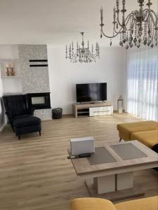 ein Wohnzimmer mit einem Kronleuchter und ein Wohnzimmer mit einem Tisch in der Unterkunft Tatranec in Lendak