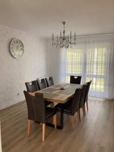 ein Esstisch mit schwarzen Stühlen und einer Uhr in der Unterkunft Tatranec in Lendak