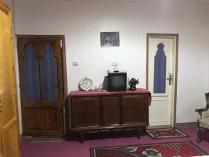 Cette chambre dispose d'une télévision sur une armoire et d'une porte. dans l'établissement Studio Farida Pyramids View, au Caire