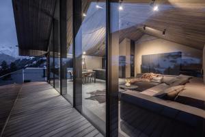 a room with a couch and a table on a deck at Paznauner Villen - Villa I in Kappl