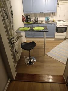 a small kitchen with a table and a stool at Aurora Center 3 in Rovaniemi
