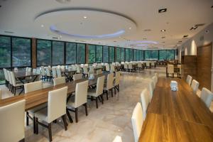 a dining room with tables and chairs and large windows at ÇAYKARA PARK HOTEL in Çaykara +36 photos