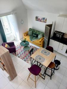 sala de estar con mesa y sillas moradas en Très bel Appartement avec superbe vue sur le Port de Saint Goustan, en Auray