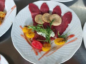 un plato de comida con carne y verduras. en Alpenlandhotel Rodeneggerhof en Rodengo