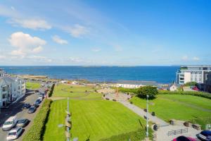 uma vista para um parque com o oceano ao fundo em Portrush Atlantic Hotel em Portrush