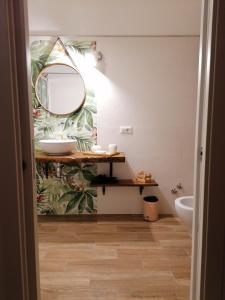 baño con lavabo y espejo en la pared en FarmaMia, en Ascea