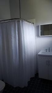 een badkamer met een wit douchegordijn en een wastafel bij Speewah Country Tavern in Speewah