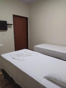 a pair of beds in a room with a door at Pousada da Praça in Ponte Alta do Norte