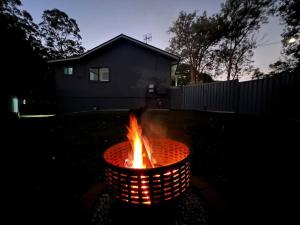 uma fogueira num quintal à noite em Ally’s Umina Oasis, pet-friendly spa coastal oasis em Umina