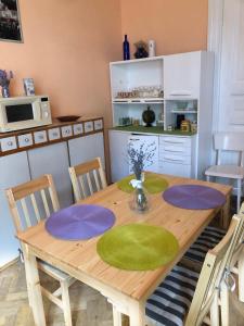 リヴィウにあるLvivskiy Zatyshok TWO Bedrooms ISOLATED with Balconyのダイニングルームテーブル(緑と紫の皿付)