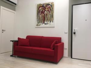 a red couch in a room with a painting on the wall at Casa Fiorella in La Spezia