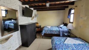 a bedroom with two beds and a tv in it at La Capitanía in Antigua Guatemala