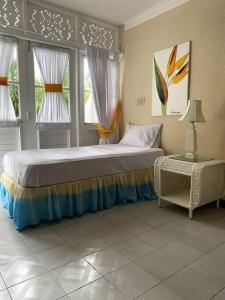 a bedroom with a large bed and two windows at Lush Tropical apartment located in a 4-star resort in Runaway Bay
