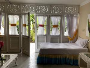 um quarto com uma cama num quarto com janelas em Lush Tropical apartment located in a 4-star resort em Runaway Bay