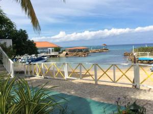 a view of the ocean from a beach with a fence at Lush Tropical apartment located in a 4-star resort in Runaway Bay