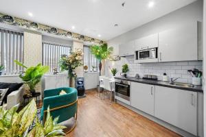 Il comprend une cuisine ouverte et un salon avec des placards blancs. dans l'établissement Boho Jungle - Luxury 1bed Apt- Long stay Discounts, à Kent