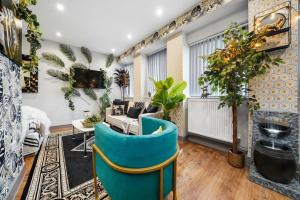 a living room with a blue chair and a couch at Boho Jungle - Luxury 1bed Apt- Long stay Discounts in Kent