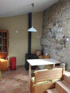 Cette chambre dispose d'une table et d'un mur en pierre. dans l'établissement Quinta do Borges, à Guarda