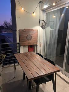 a wooden table on a balcony with a clock on the wall at El Porteño in San Pedro