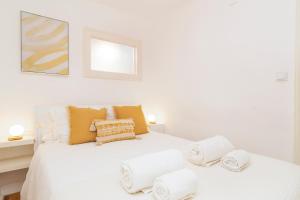 a bedroom with a white bed with towels on it at Alfama Patio Apartments in Lisbon