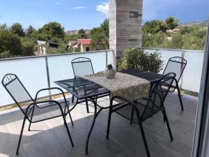 a patio table and chairs on a balcony at Apartament Maja in Rogoznica