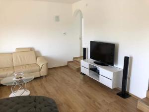 a living room with a couch and a flat screen tv at Apartament Maja in Rogoznica