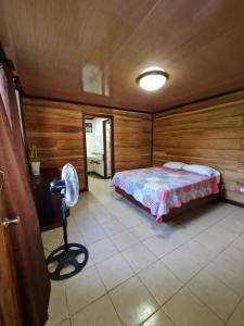 a bedroom with a bed and a fan in it at Casa Samia in Cahuita